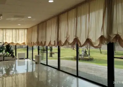 Interni del ristorante con grandi finestre e vista sul giardino.