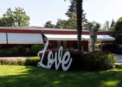 Scultura Love e natura rigogliosa creano atmosfera romantica all'aperto.